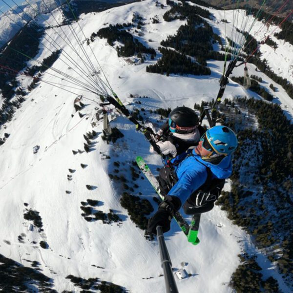 Vol en parapente à ski au dessus de la montagne enneigée